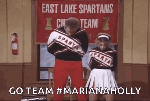 a couple of cheerleaders are standing in front of a sign that says east lake spartans