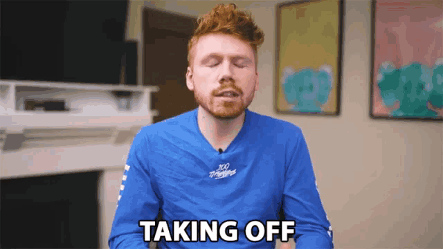 a man in a blue shirt is taking off