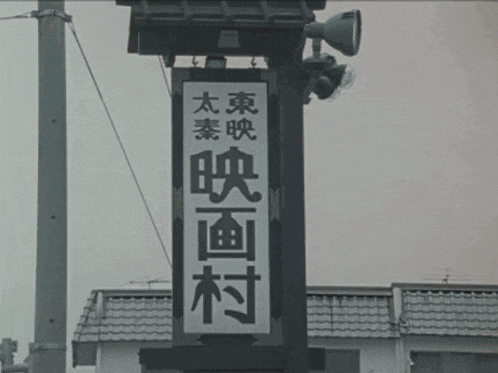 a black and white photo of a sign with chinese writing on it