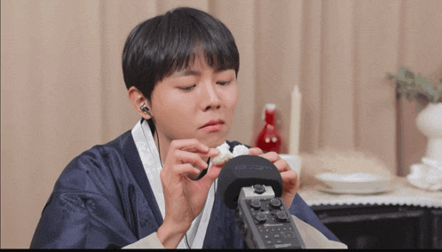 a person wearing a blue robe is holding a boombox