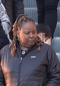 a woman with dreadlocks is wearing a black patagonia jacket .