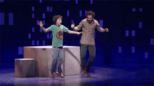 a man and a young boy are dancing on a stage .