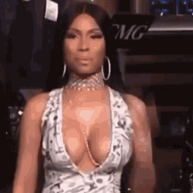 a woman in a very plunging dress is standing in front of a microphone .