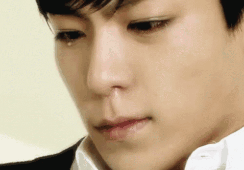 a close up of a young man 's face with a tear coming out of his nose .