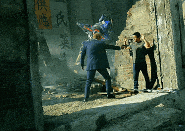 a man in a suit stands next to a robot with chinese writing on the wall behind them