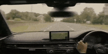 a person is driving down a road in an audi car