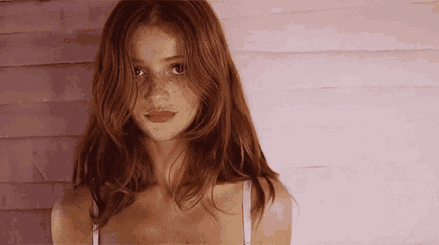 a woman with red hair is wearing a white bra
