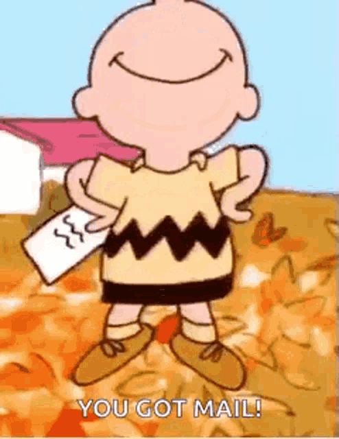 charlie brown is holding a piece of paper and smiling while standing in a field .