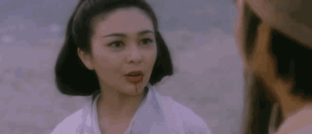 a woman with blood on her lips is talking to a man .