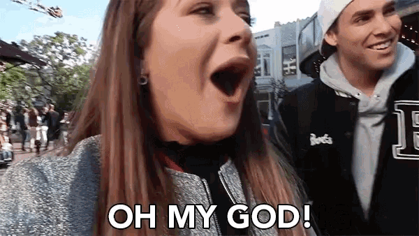 a woman with her mouth open says oh my god while standing next to a man