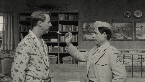 a man in a military uniform talks to another man