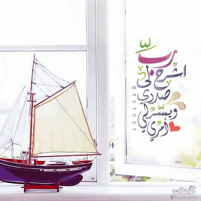 a model sailboat sits in front of a window with arabic writing