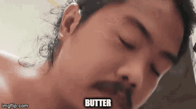 a close up of a man 's face with the word butter written on it