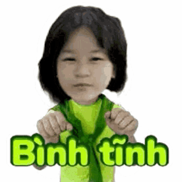 a little girl is wearing a green shirt and tie and has a sticker on her face .