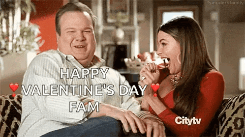 a man and a woman are sitting on a couch and the woman is holding a glass of wine in her mouth .