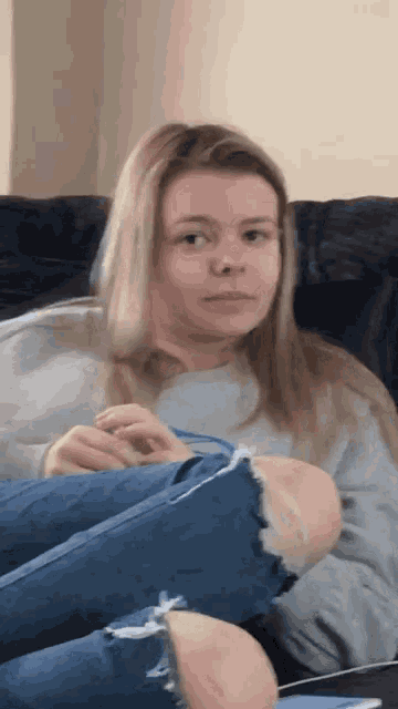 a woman sitting on a couch with her legs crossed