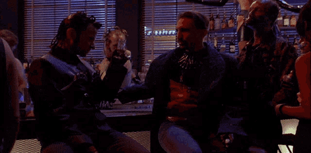 a group of men sitting at a bar drinking