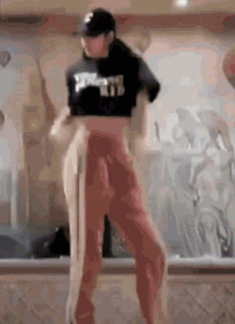 a woman in a crop top and red pants is dancing .