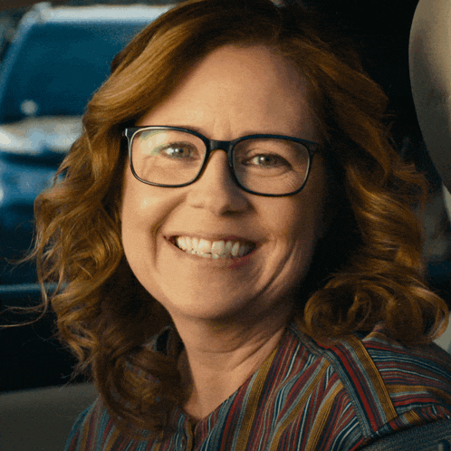 a close up of a woman wearing glasses smiling