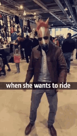 a man wearing a horse mask and sunglasses stands in a crowded room with the words when she wants to ride below him