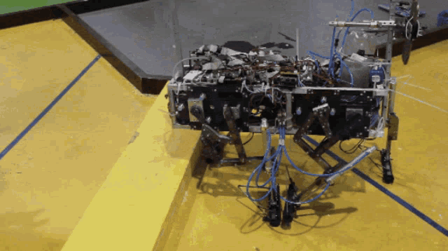 a robot with a bunch of wires coming out of it 's legs