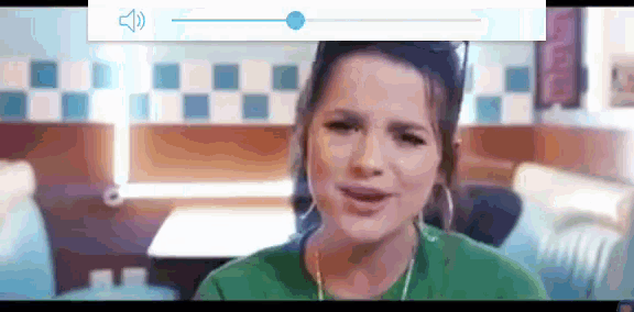 a woman wearing headphones is sitting in a diner and singing .