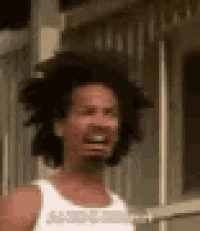 a man with curly hair and a beard is making a funny face while wearing a white tank top .