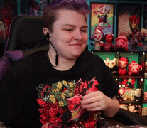 a woman with purple hair wearing headphones and a black shirt