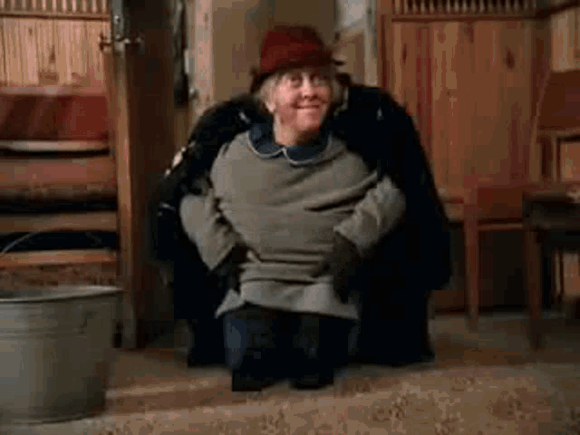 a man is kneeling down next to a woman in a room .