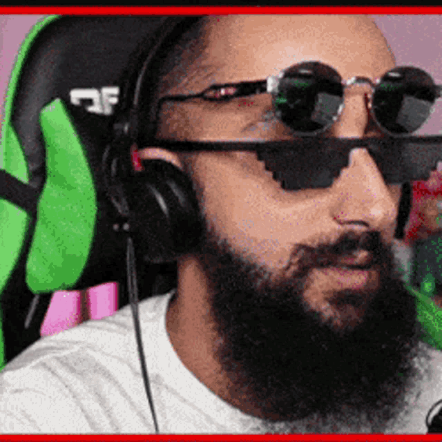 a man with a beard and sunglasses is wearing headphones .