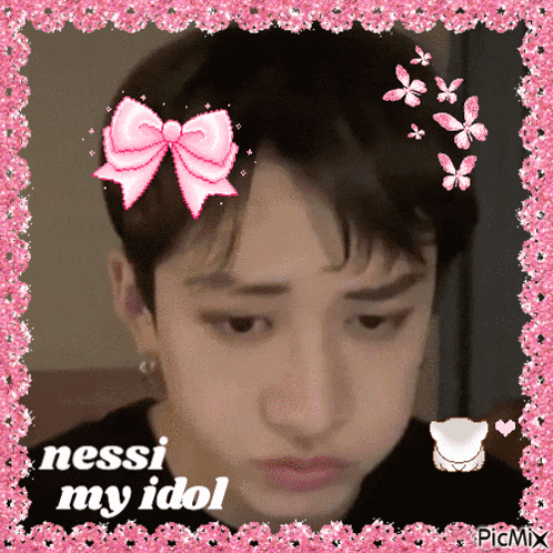 a picture of a boy with a pink bow on his head and the words nessi my idol on the bottom