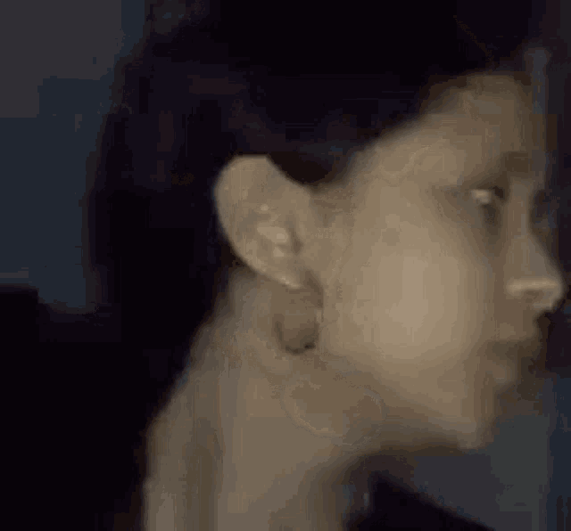 a close up of a woman 's face with hoop earrings on .
