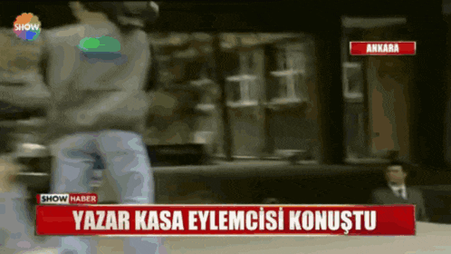 a man is standing in front of a sign that says ' yazar kasa eylemcisi konustu '