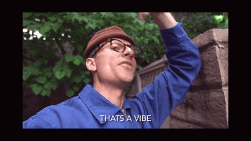a man wearing glasses and a hat says thats a vibe