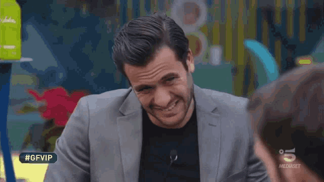 a man in a suit is smiling in front of a sign that reads #gfvip