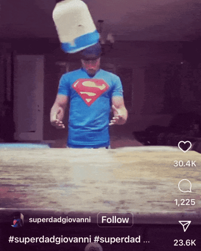 a man in a superman t-shirt is throwing a bucket on top of a table