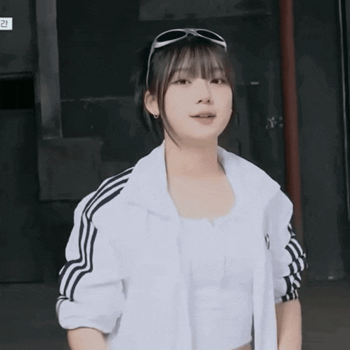 a girl wearing sunglasses and a white jacket has the number 2 on the bottom right