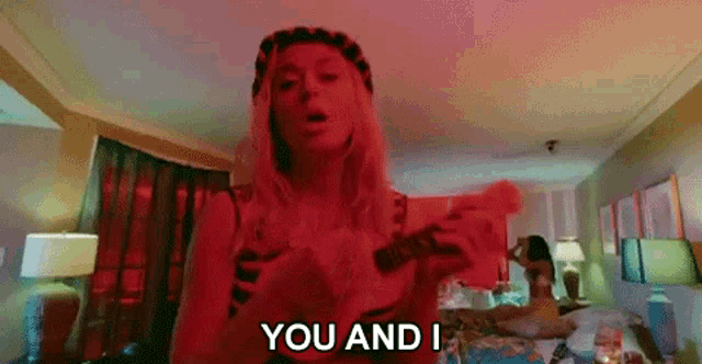 a woman is holding a gun and saying `` you and i '' .