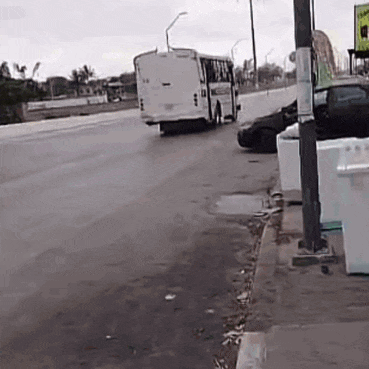 a white bus is driving down a street next to a sign that says stop
