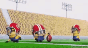 a group of minions wearing football helmets and holding a football on a field