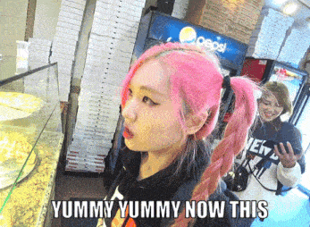 a girl with pink hair stands in front of a pepsi cooler