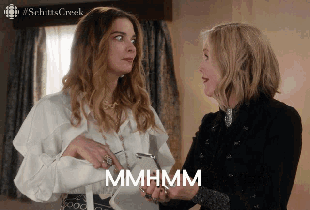 two women standing next to each other with the word mhmhm on the bottom right
