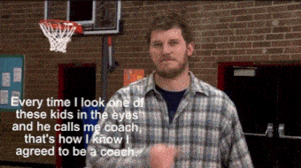 a man in a plaid shirt is standing in front of a brick wall and a basketball hoop