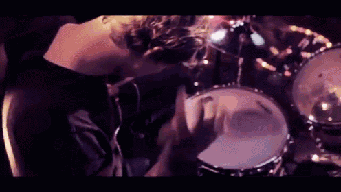 a man in a black shirt is playing drums