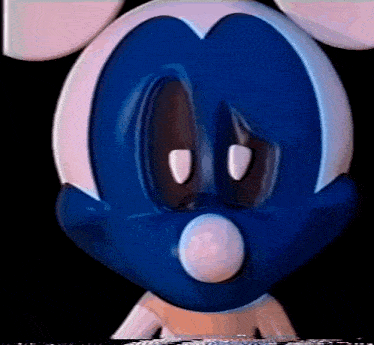 a close up of a blue and white cartoon character 's face with a surprised look on his face .