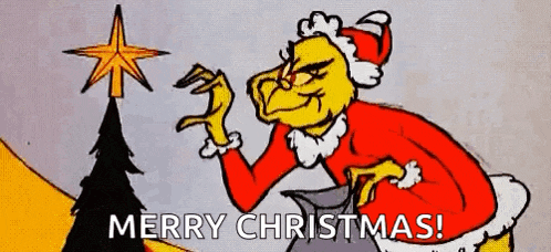 the grinch is putting a star on top of a christmas tree and wishing merry christmas .
