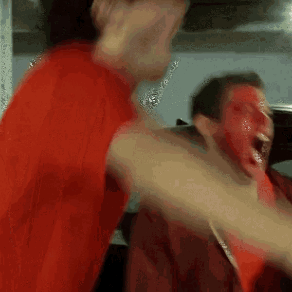 a man with red paint on his face is being punched in the face