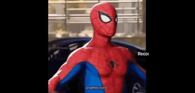 a spider man is standing in front of a car .