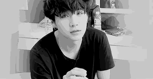 a black and white photo of a young man in a black t-shirt .