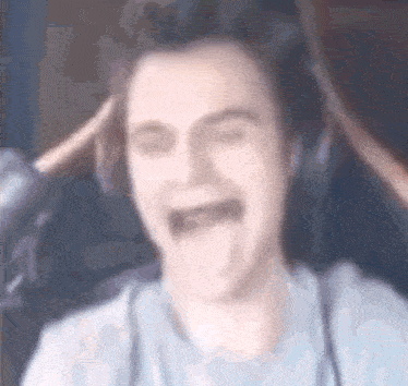 a blurry picture of a man wearing headphones and making a face .